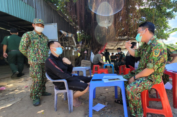 지난 18일 캄보디아의 카지노 노예노동에 강을 건너 탈출, 돌아온 베트남인들이 국경수비대의 조사를 받고 있다. / 사진=베트남 국경수비대