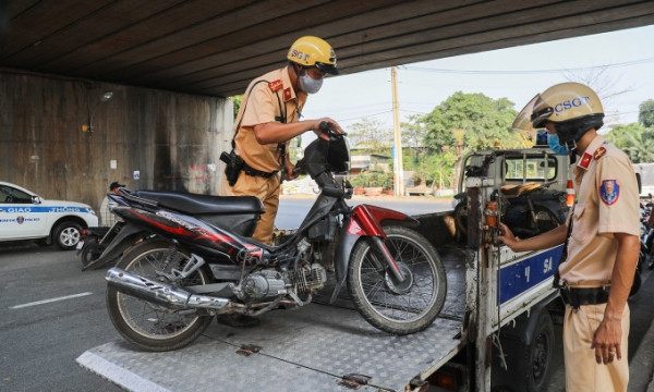 Traffic police officers seize a motorbike in HCMC. Photo by VnExpress/Quynh Tran